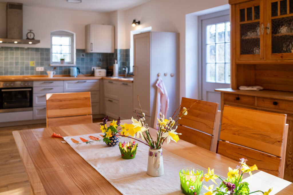 Blumen auf dem Küchentisch laden zu Gemütlichkeit ein